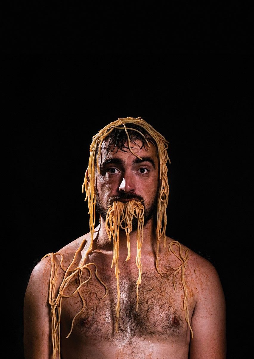Homme avec assiette de spaghettis renversés sur la tête